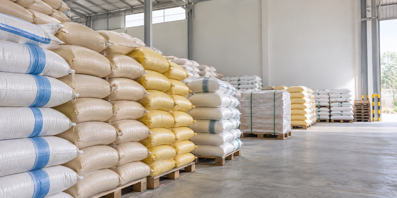 Stacks of filled woven polypropylene sacks on pallets in a dispatch warehouse